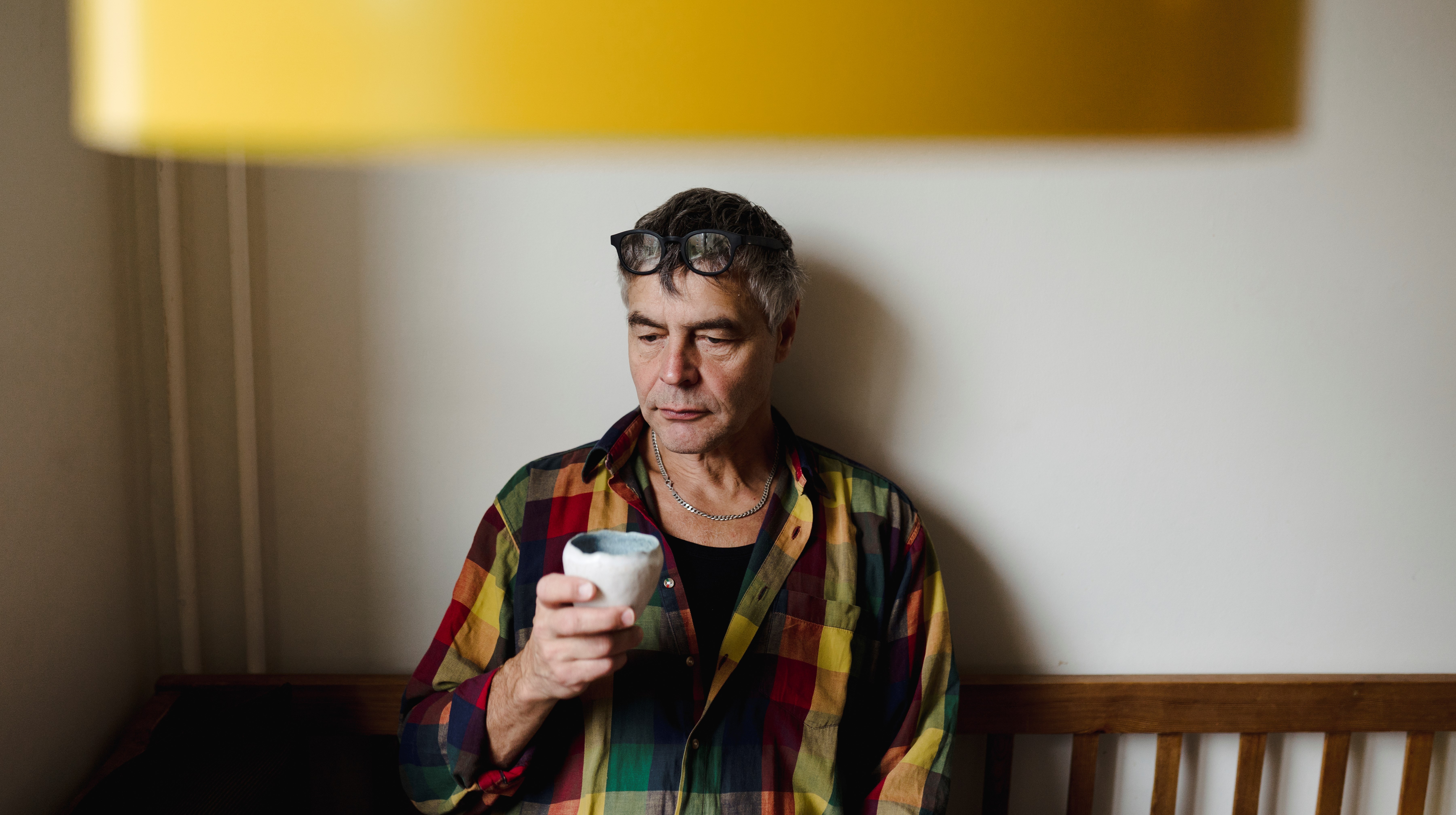 Man med kaffekopp i kökssoffa