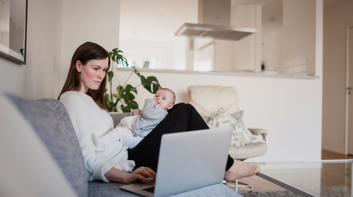 En mamma med sitt barn som sitter vid en dator.