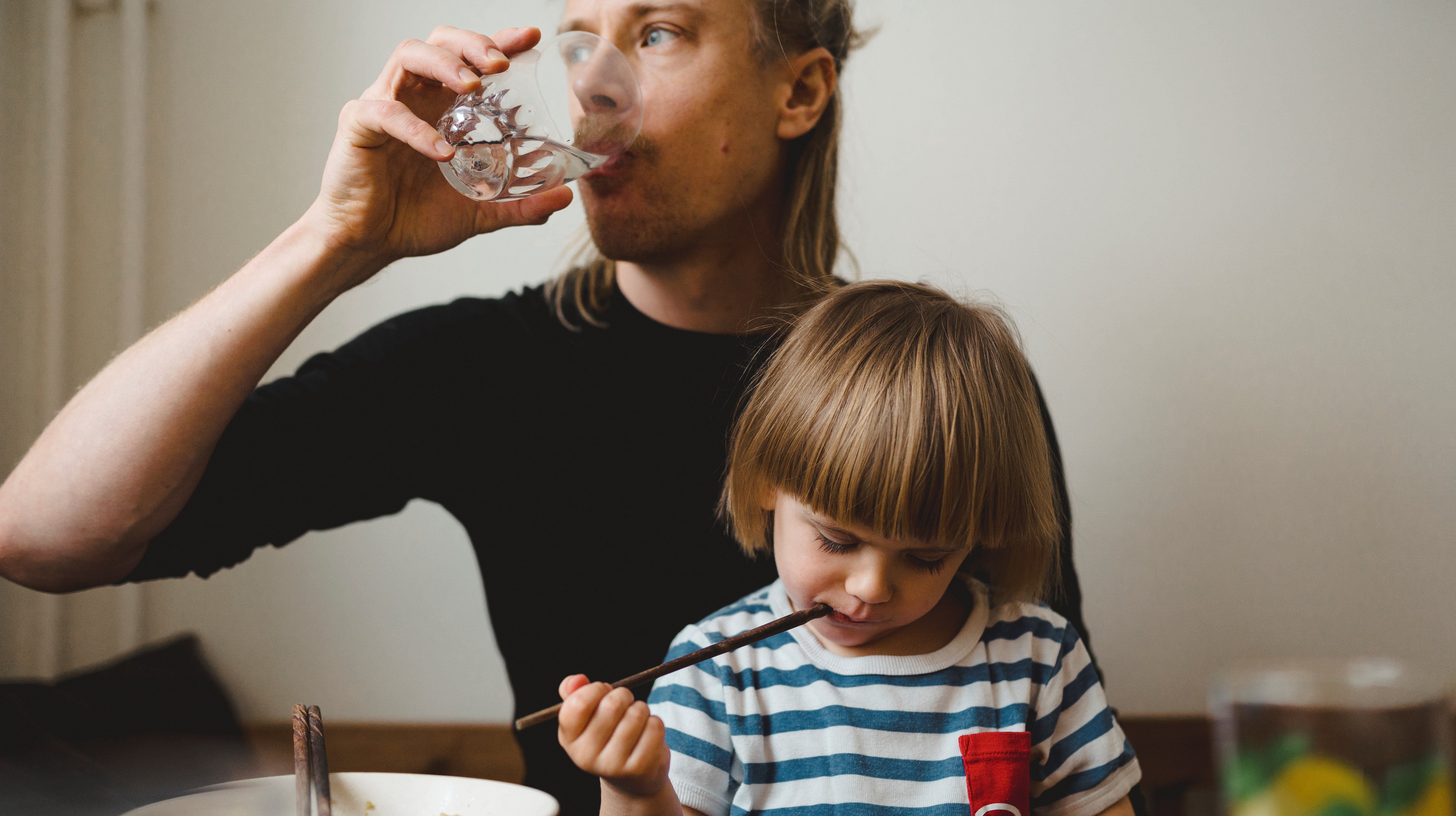 En pappa med sitt barn vid matbordet. 